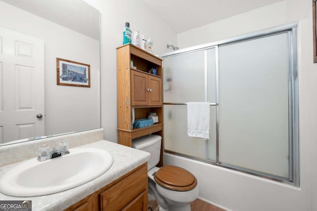 full bathroom featuring vanity, a textured ceiling, bath / shower combo with glass door, and toilet