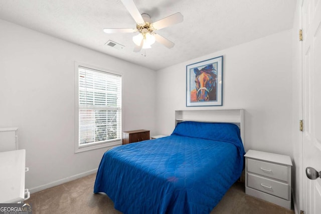 bedroom with dark colored carpet, a textured ceiling, and ceiling fan