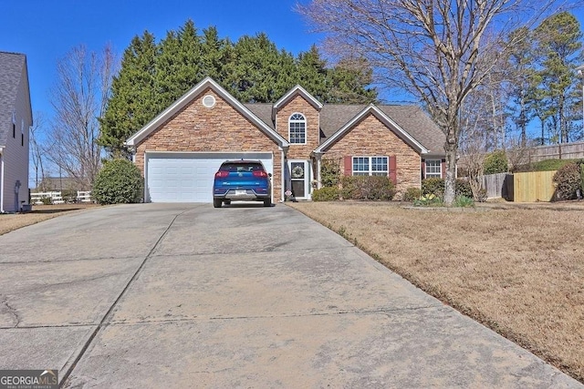 view of front of house featuring stone siding, driveway, a garage, and fence