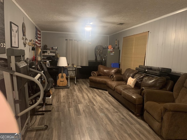 living room featuring hardwood / wood-style floors, ornamental molding, and a textured ceiling