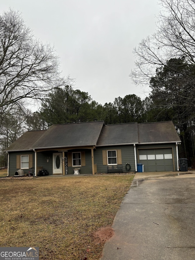 ranch-style house featuring a garage and a front lawn