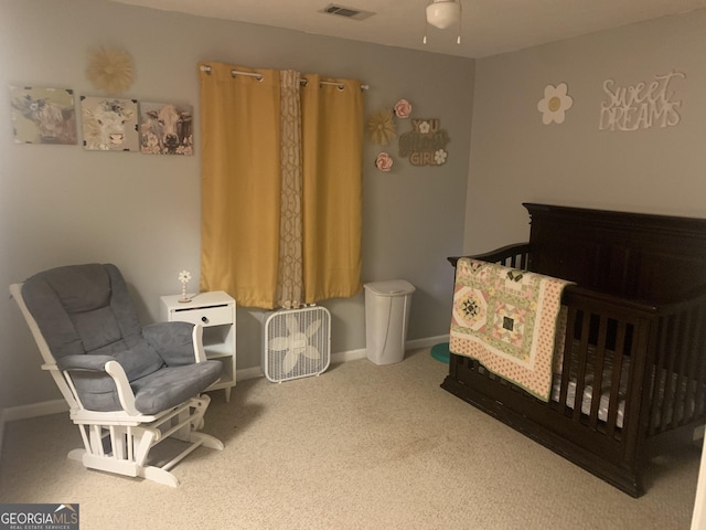 bedroom featuring a nursery area and carpet flooring