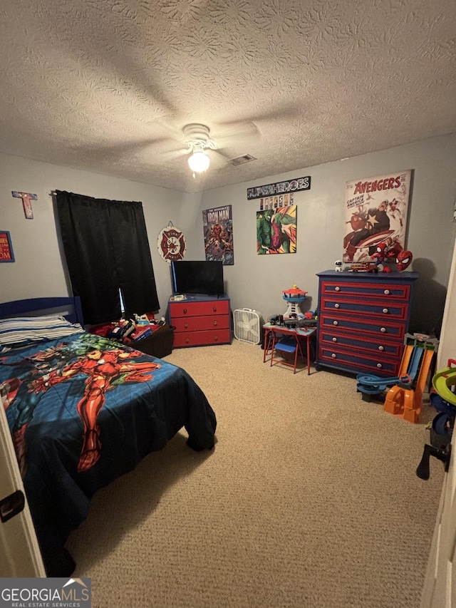 carpeted bedroom featuring a textured ceiling and ceiling fan