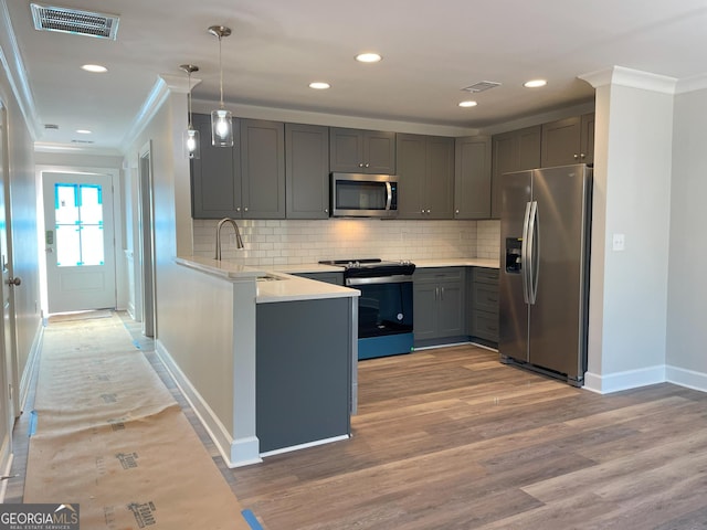 kitchen featuring hanging light fixtures, gray cabinets, stainless steel appliances, and kitchen peninsula