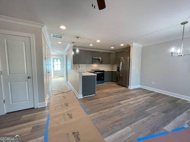 kitchen featuring crown molding, appliances with stainless steel finishes, gray cabinetry, backsplash, and decorative light fixtures