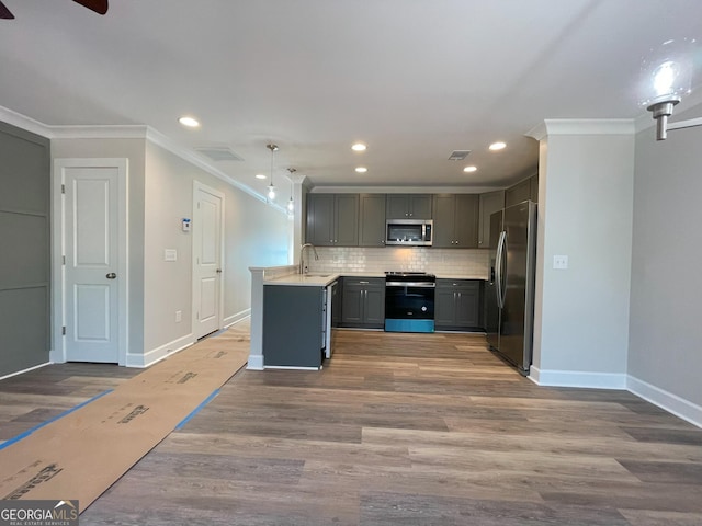 kitchen featuring hardwood / wood-style flooring, gray cabinetry, hanging light fixtures, backsplash, and stainless steel appliances