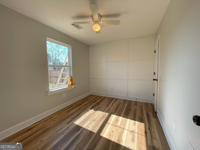 spare room with dark hardwood / wood-style floors and ceiling fan