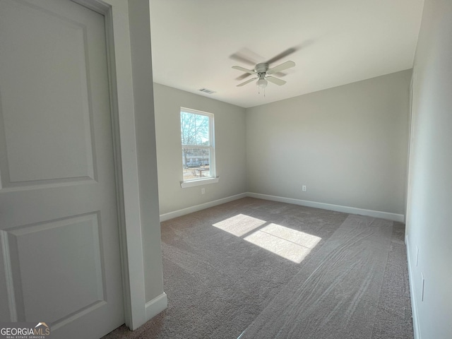 carpeted spare room featuring ceiling fan