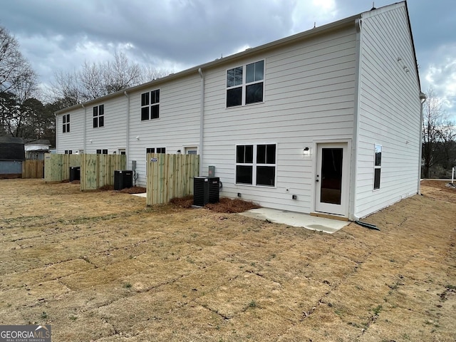 back of property with a lawn and central air condition unit