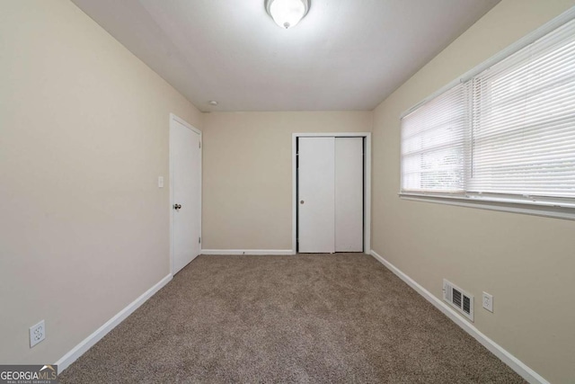 unfurnished bedroom featuring a closet and carpet flooring