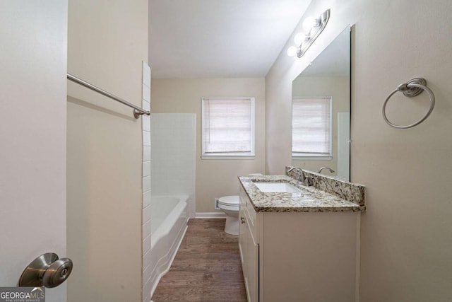 full bathroom featuring shower / bath combination, vanity, hardwood / wood-style floors, and toilet