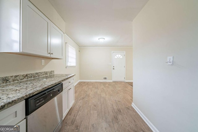 kitchen with light stone counters, white cabinetry, stainless steel dishwasher, and light hardwood / wood-style floors