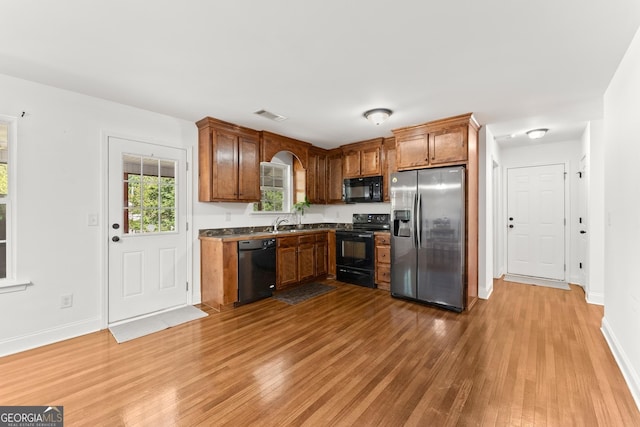 kitchen featuring wood-type flooring and black appliances