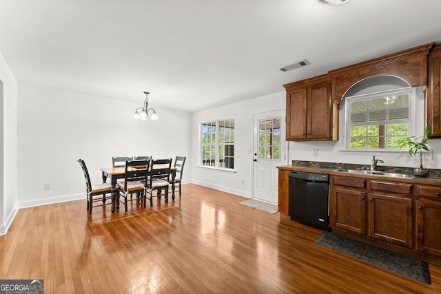 kitchen with sink, dishwasher, hanging light fixtures, plenty of natural light, and light wood-type flooring