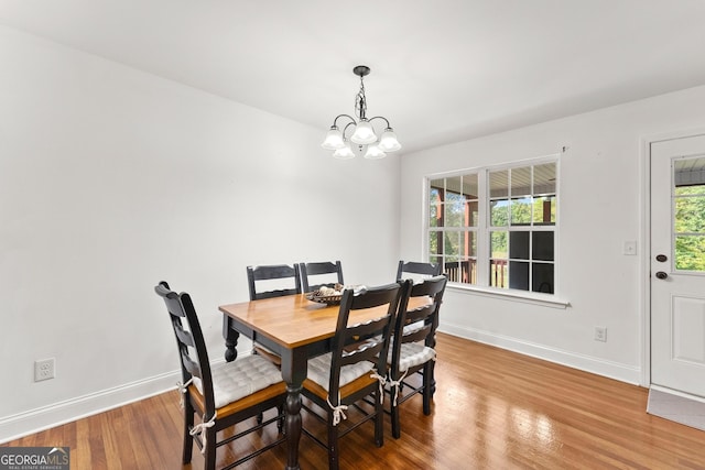 dining space featuring hardwood / wood-style floors and a chandelier