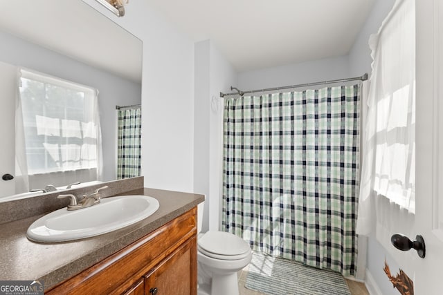 bathroom with vanity, curtained shower, and toilet