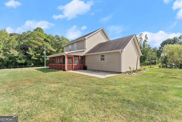 back of house featuring a patio, a yard, and a sunroom