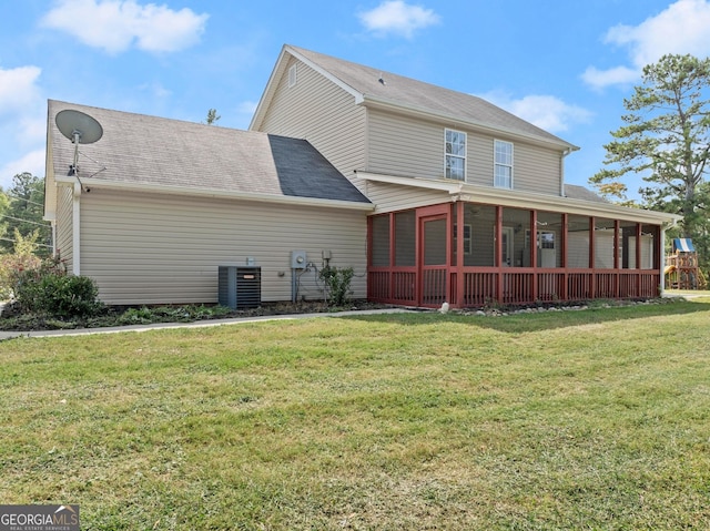 back of house featuring central AC, a sunroom, and a lawn