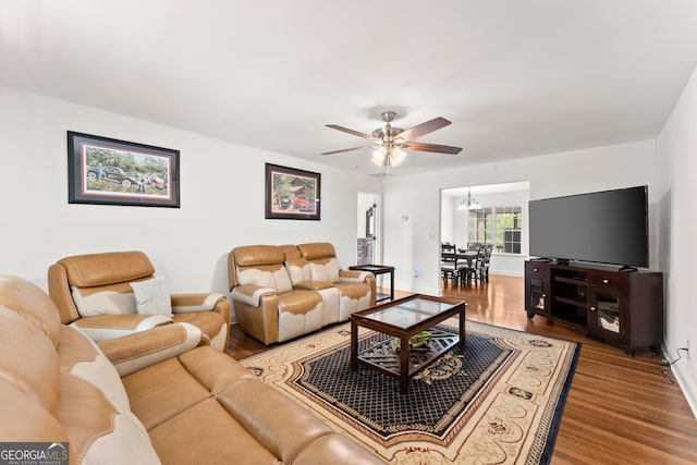 living room with ceiling fan with notable chandelier and wood-type flooring