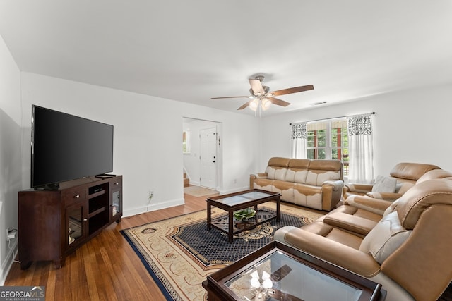 living room with dark wood-type flooring and ceiling fan