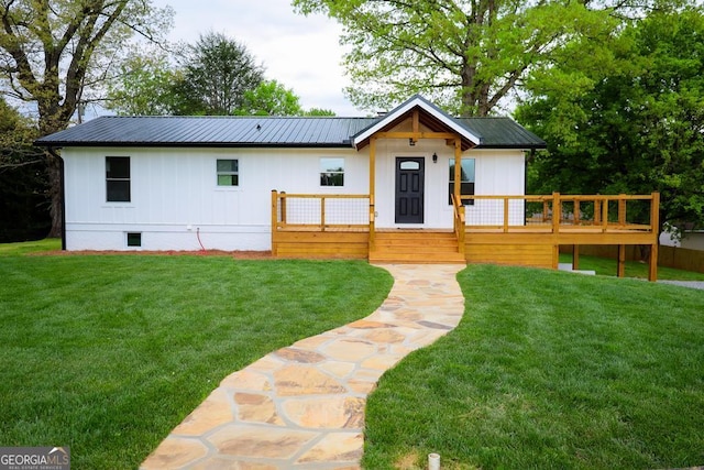 modern farmhouse featuring a wooden deck and a front lawn