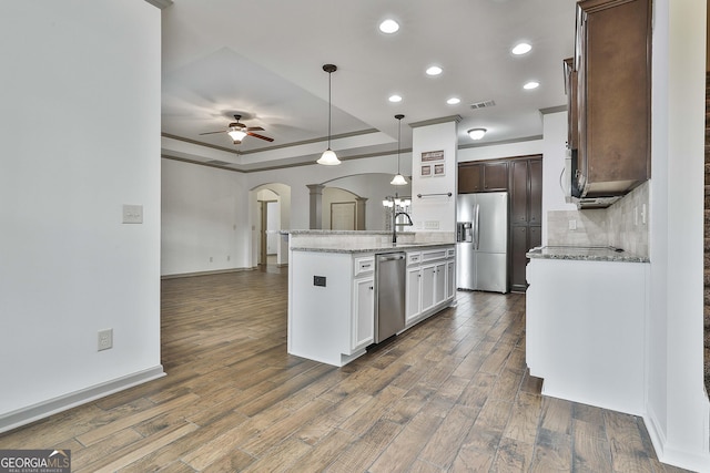 kitchen with arched walkways, stainless steel appliances, visible vents, dark wood-type flooring, and ceiling fan