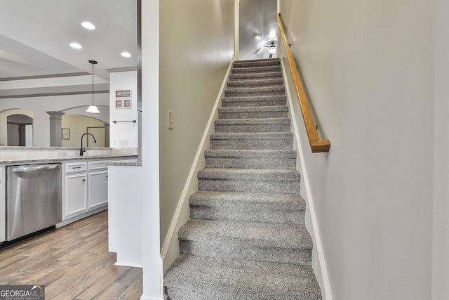 stairway featuring baseboards, wood finished floors, and recessed lighting