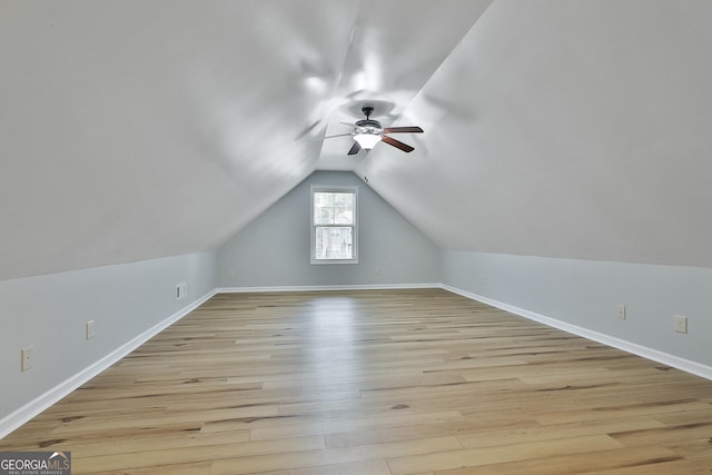 bonus room with baseboards, vaulted ceiling, light wood finished floors, and ceiling fan