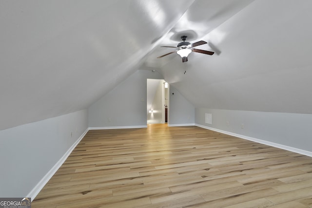 additional living space with ceiling fan, visible vents, baseboards, vaulted ceiling, and light wood finished floors