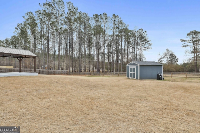 view of yard with an outbuilding, a storage unit, and fence