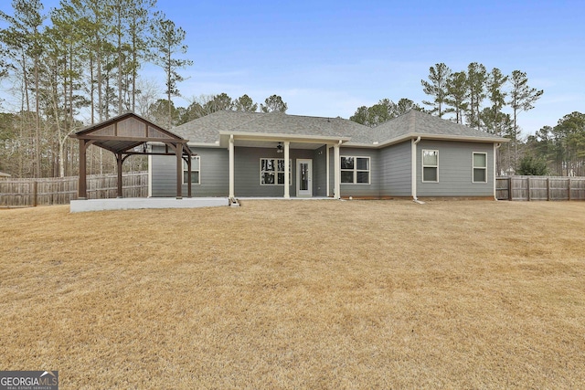 back of house with roof with shingles, fence private yard, a gazebo, a yard, and a patio area