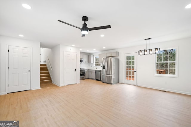 unfurnished living room featuring ceiling fan and light hardwood / wood-style floors