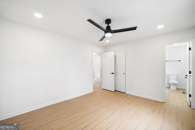 unfurnished bedroom featuring ceiling fan, ensuite bath, and light wood-type flooring