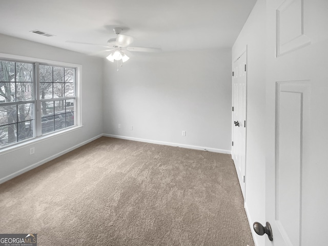 carpeted spare room with ceiling fan