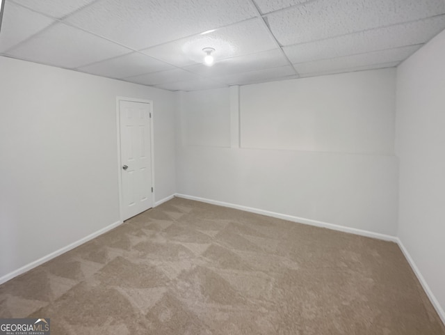 empty room featuring carpet and a paneled ceiling