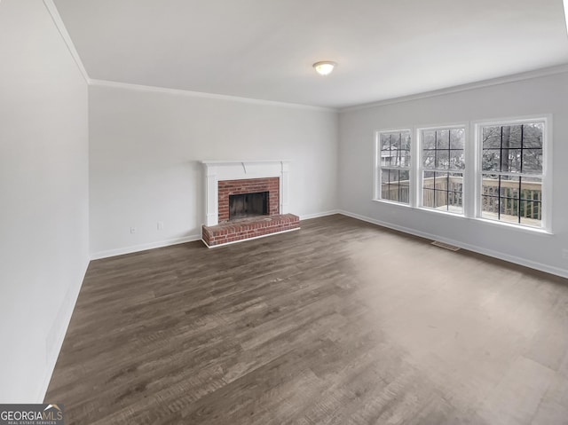 unfurnished living room featuring crown molding, a brick fireplace, and dark hardwood / wood-style flooring