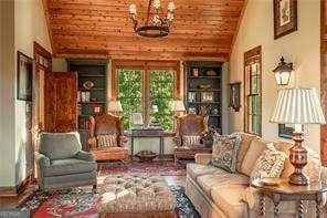 living area featuring wooden ceiling, vaulted ceiling, and an inviting chandelier