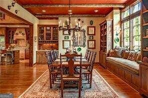 dining space featuring a chandelier, beamed ceiling, and wood finished floors