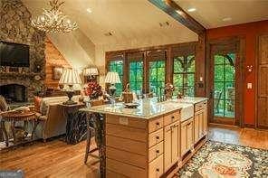 bar with a healthy amount of sunlight, light wood-style floors, and a fireplace