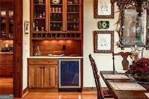 bar with wine cooler, light wood-style flooring, and a dry bar