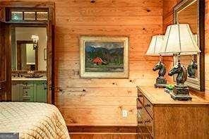 bedroom featuring wood walls and ensuite bath