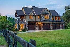 view of front of home with a garage, fence, driveway, and a front lawn