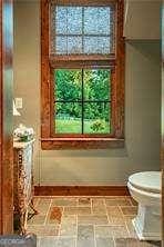 bathroom with toilet and baseboards