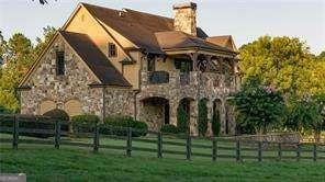 view of front of home featuring stone siding, a fenced front yard, and a front yard