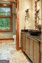 full bathroom with baseboards, vanity, and toilet