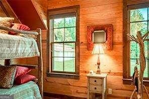 bedroom featuring wooden walls