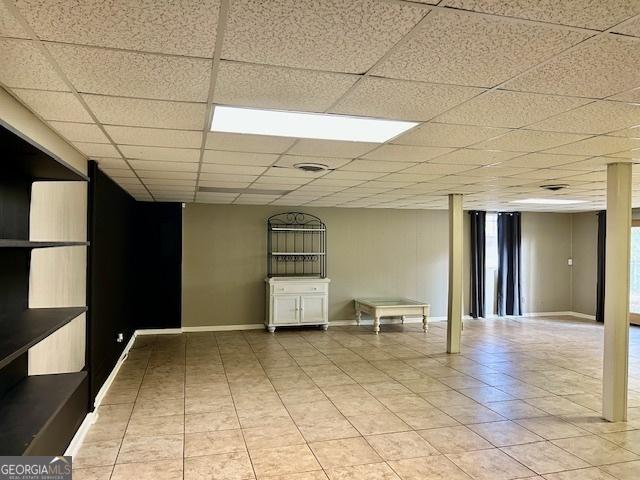 unfurnished room featuring tile patterned flooring and a drop ceiling