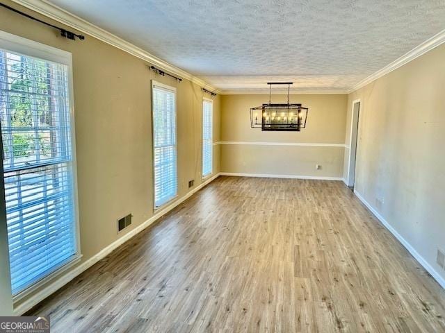 unfurnished dining area with crown molding, hardwood / wood-style flooring, and a textured ceiling