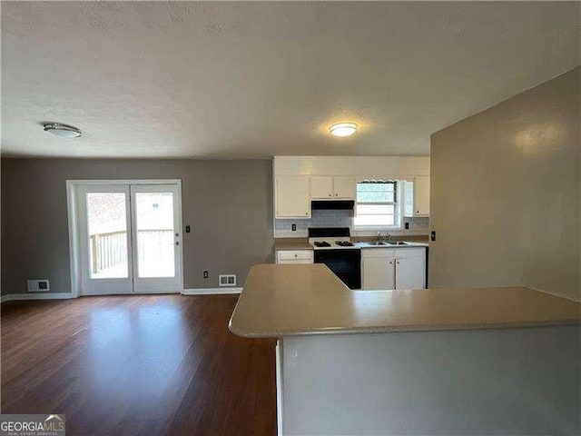 kitchen with sink, white cabinets, decorative backsplash, range, and dark wood-type flooring