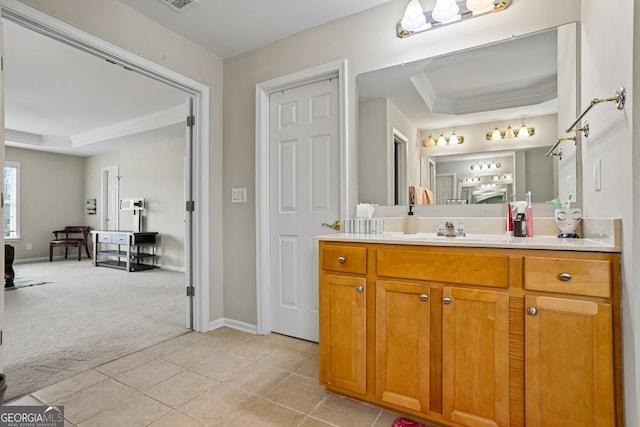 bathroom featuring tile patterned flooring, vanity, crown molding, and a tray ceiling